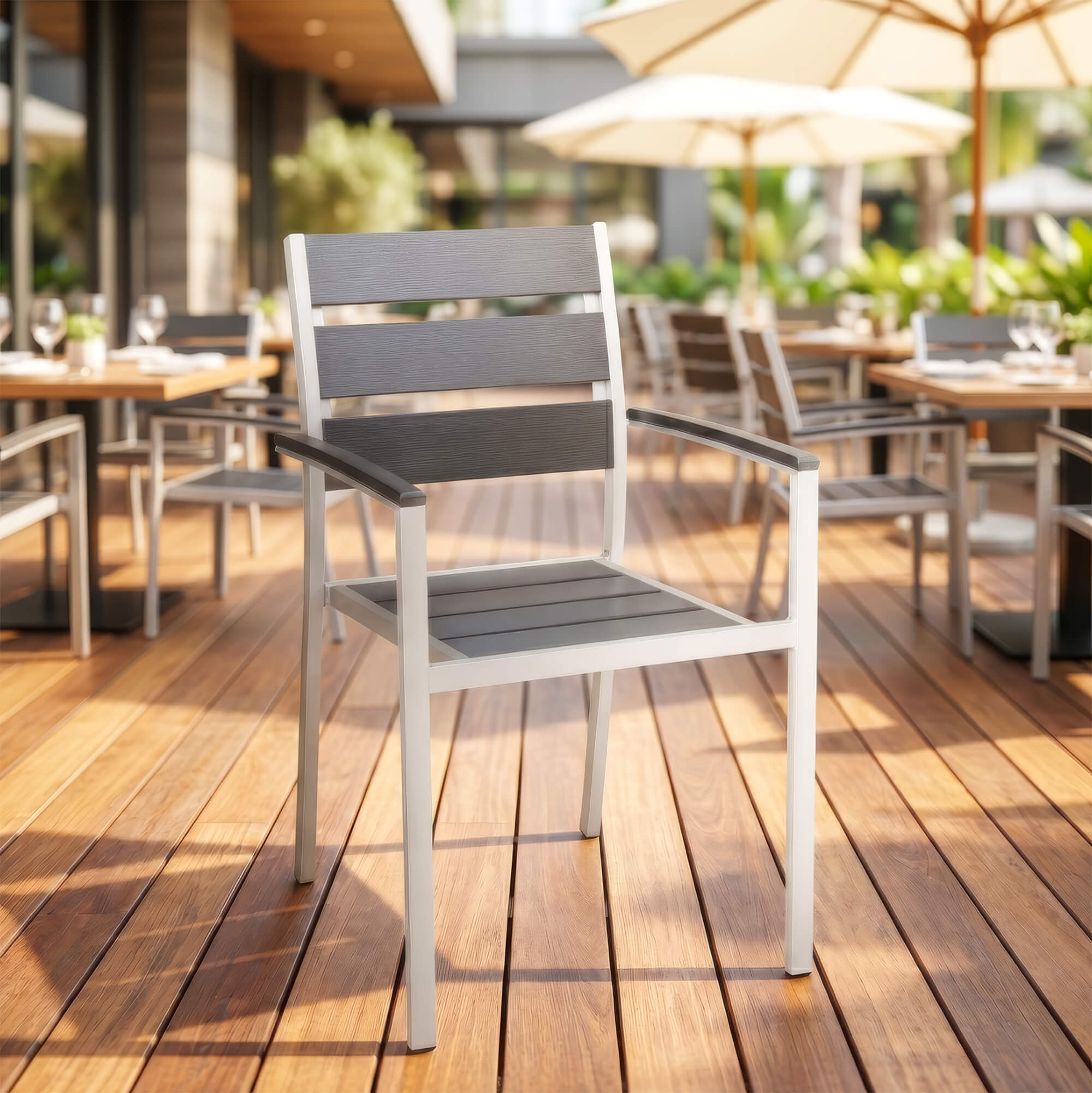 Stapelbarer Outdoorstuhl in Grau für Gastronomie-Terrassen Stapelbarer Outdoorstuhl in Grau mit Armlehnen auf Restaurant-Terrasse